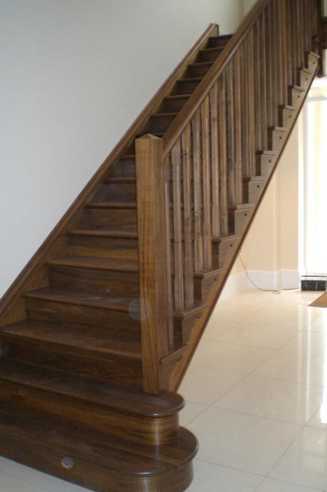 Staircase with Open Strings and Curved Bottom Treads made in American Walnut and French Polished