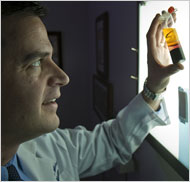 Scientist examines vial of plasma in promising research study of injury-recovery treatment for athletes.