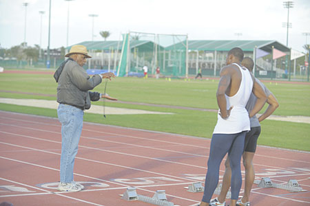 Brooks Johnson (left) counsels track athletes