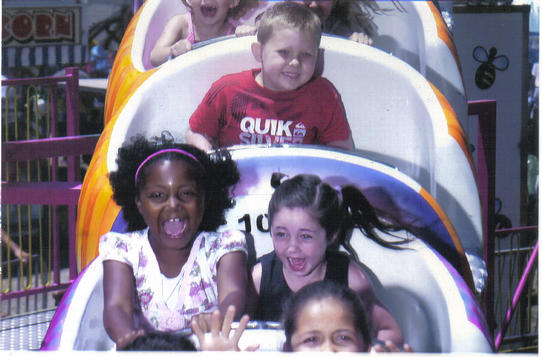 Kristen Webb (seated left in center car), the coach's daughter screams in delight during break in the action on recent trip with the team.