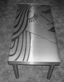A stainless steel coffee table with a design polished onto the surface