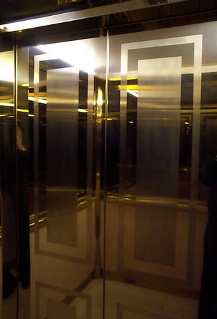 Brass lift doors with a simple but very effective boarder design