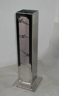 A tall slender vase that has been polished to a mirror finish, then had the design polished on top