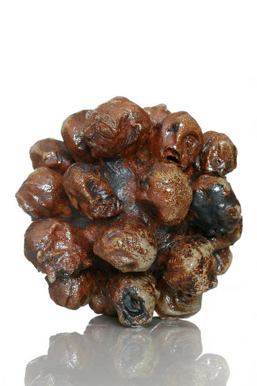 A ball of heads, about the size of a small football but comprising of lots of anguished looking heads.