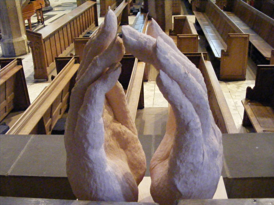 Stoneware Hands in a prayer like gesture of peace or namaste, about 80 cms tall, echoing the Gothic arch forms beyond