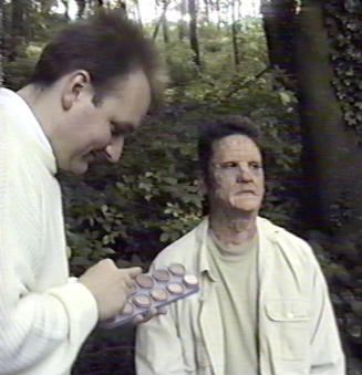 Carl standing next to Evil Father out of costume applying makeup