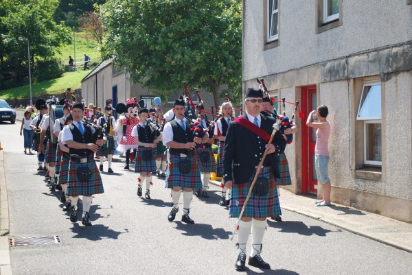 Strathisla Pipe Band leading the childrens fancy dress parade from the village hall to the arena