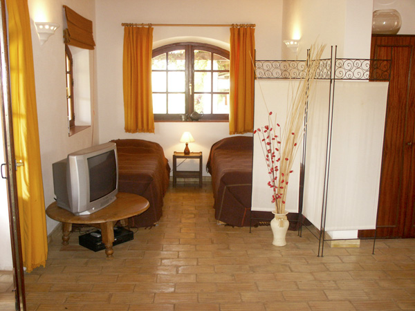 Twin bed area in Casa Limão with privacy screen