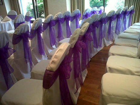 white chair covers with purple organza sashes